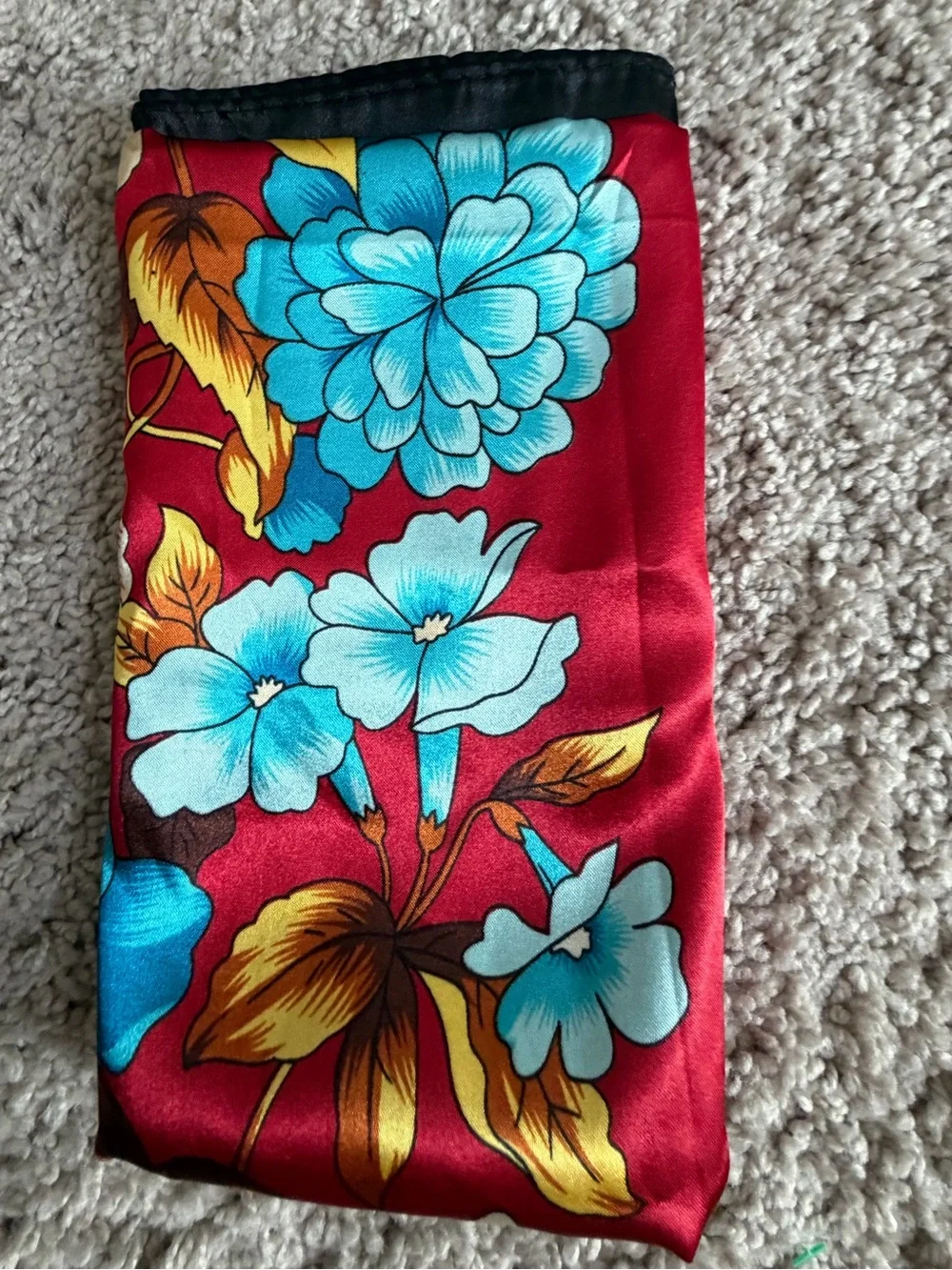 red and black silk like square scarf features a bold turquoise and blue